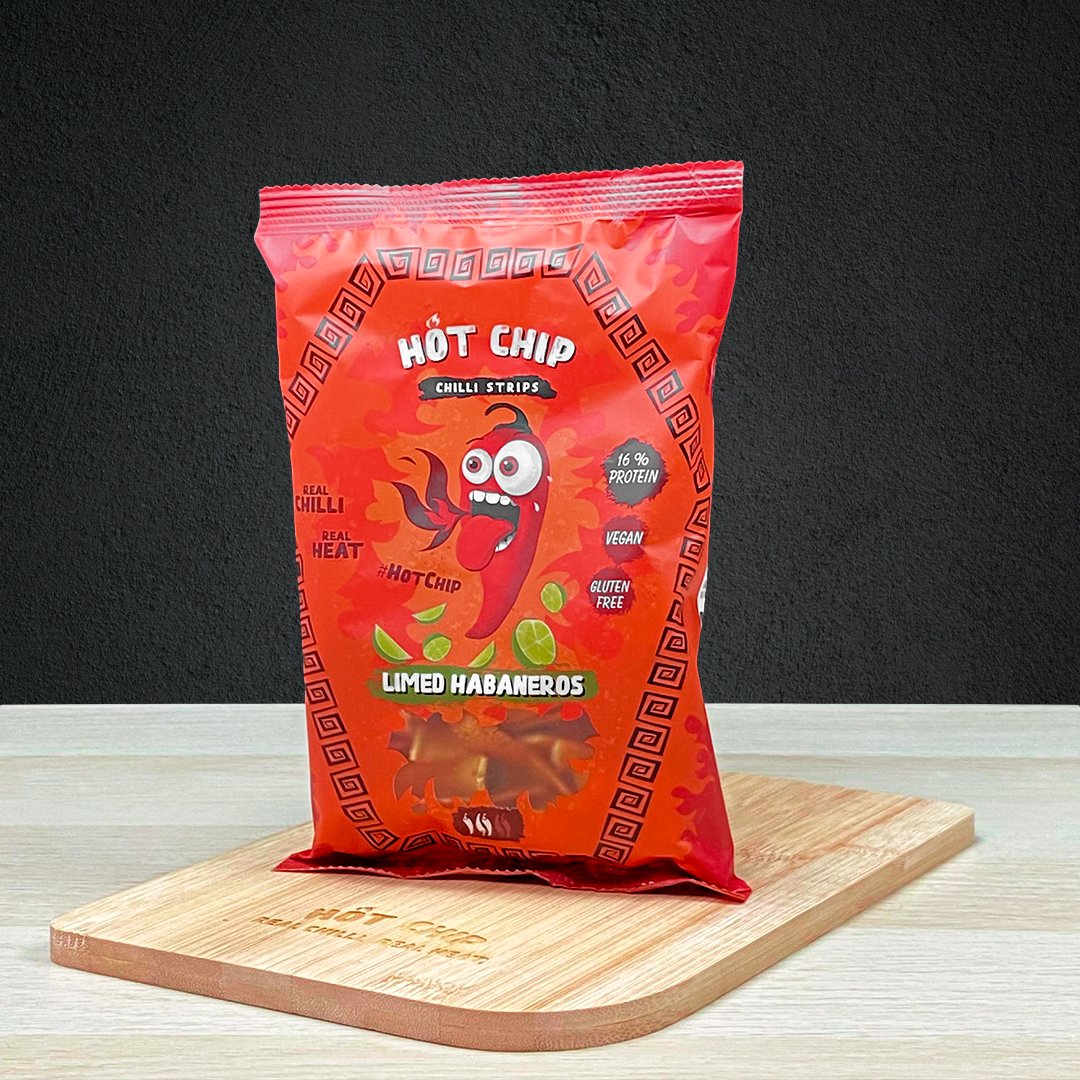 Un paquet rouge sur une planche en bois, derrière un mur noir