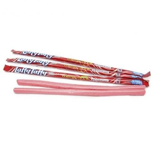 3 emballages roses sur fond blanc avec des cerises rouges et juste devant 2 bonbons en forme de bâtonnets roses déballés