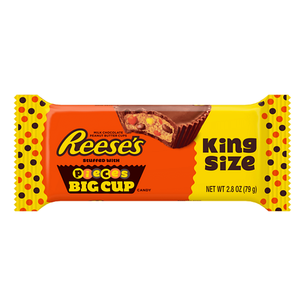 Un emballage orange avec des extrémités jaunes sur fond blanc avec écrit « Reese’s » à gauche et à droite il y a un chocolat en cup qui est croqué et on y voit une pâte brune claire avec des morceaux colorés