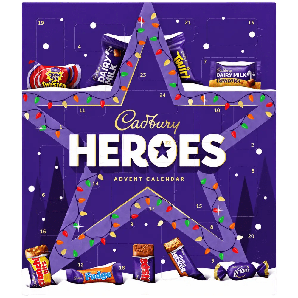 Calendrier de l'Avent Cadbury Heroes violet avec chocolats assortis, présenté dans un décor de Noël avec sapin et cadeaux.