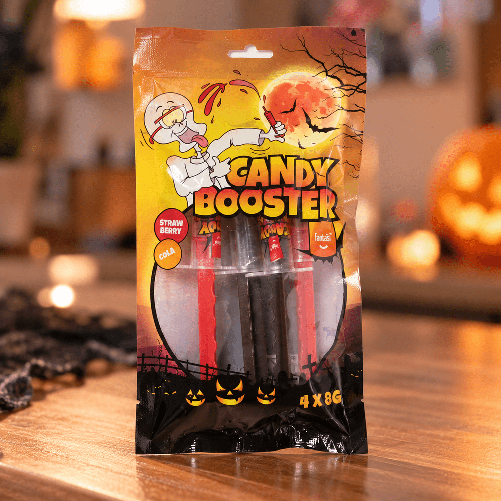 Sachet Candy Booster Halloween 4 x 8 g contenant des bonbons fraise et cola, présenté dans un décor avec citrouille illuminée.
