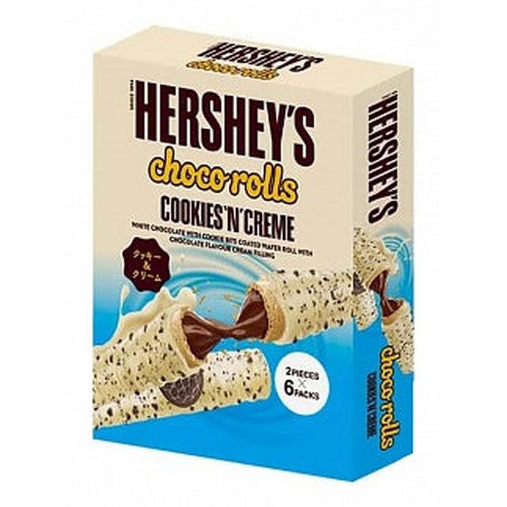 Un carton beige et bleu sur fond blanc avec un biscuits au chocolat blanc coupé en 2 avec à l’intérieur du chocolat au lait