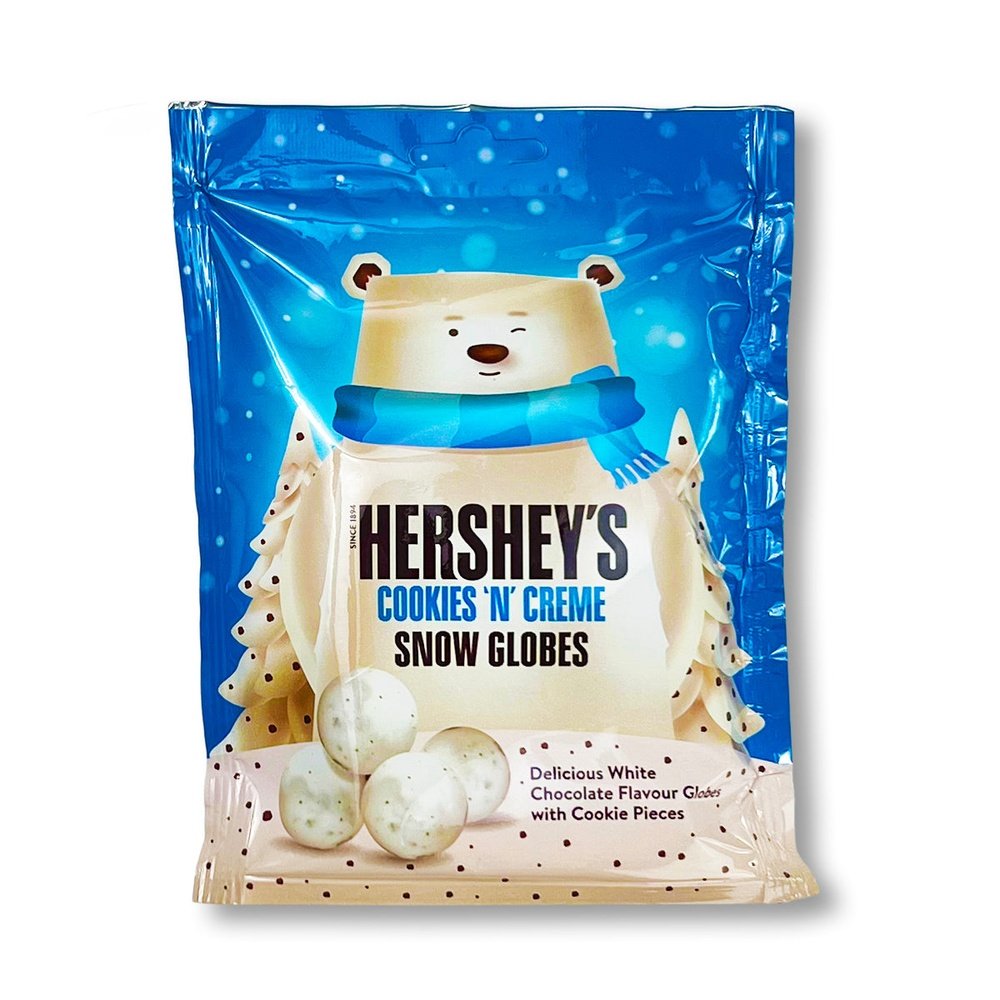 Un paquet bleu brillant sur fond blanc avec un immense ours blanc qui fait un clin d’oeil et entouré de 2 sapin blanc. Devant lui se trouve 5 Hershey’s Snow Globes