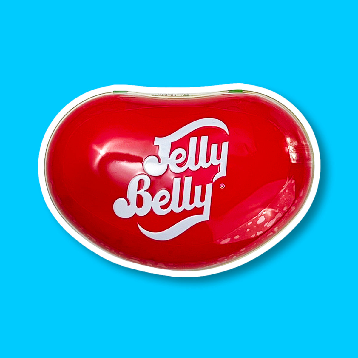 Une grande boite rouge en forme d’haricots avec écrit en blanc « Jelly Belly ». Le tout sur fond bleu