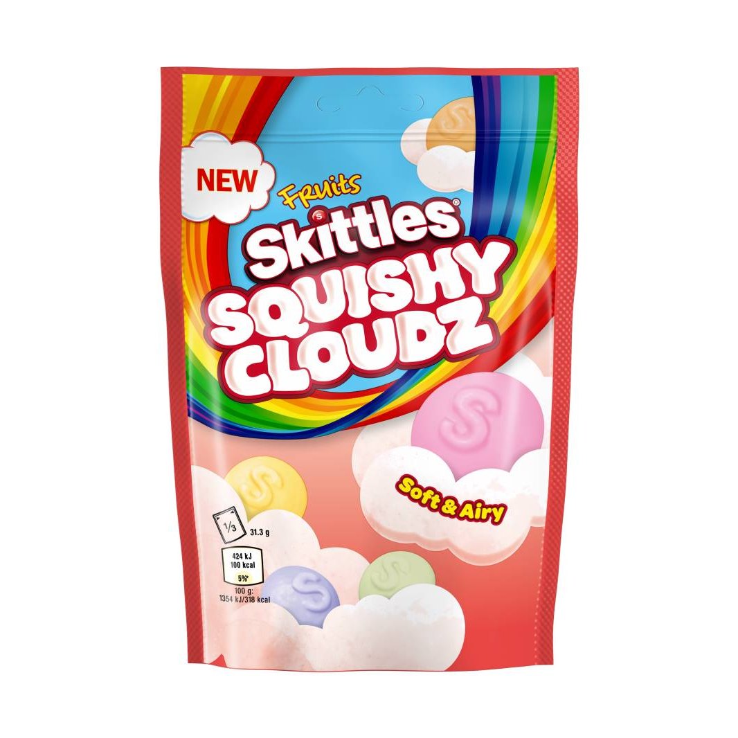 Un emballage rouge sur fond blanc avec un arc-en-ciel et des Skittles colorés sur des nuages roses pâles