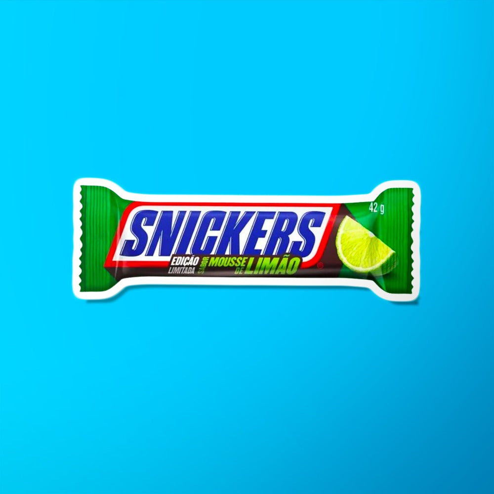 Un emballage vert sur fond bleu avec au centre écrit « Snickers » en bleu et sur le côté droit il y a une part de citron vert