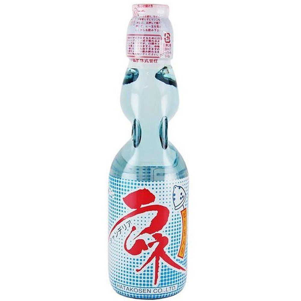 Une bouteille transparente sur fond blanc avec une boisson transparente, il y a une étiquette blanche à points bleus sur la moitié basse de la bouteille